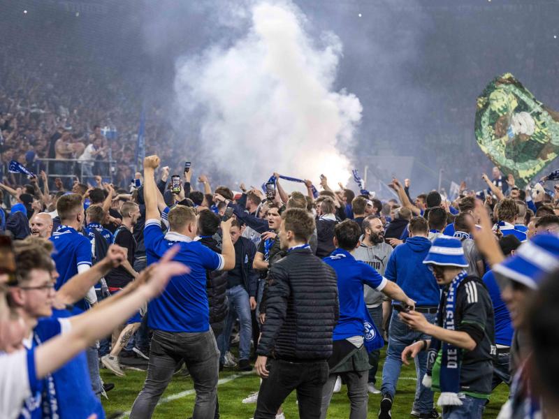 Die Schalker Fans stürmten nach dem Aufstieg den Platz. Foto: David Inderlied/dpa