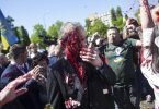 Sergej Andrejew (M.), russischer Botschafter in Polen, wird bei einer Kranzniederlegung auf dem Friedhof für die gefallenen sowjetischen Soldaten im Zweiten Weltkrieg in Warschau von Demonstranten mit roter Farbe bespritzt. Foto: Maciek Luczniewski/AP/dpa
