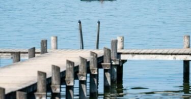Ein Mann auf seinem Ruderboot angelt auf dem Ammersee in der Bucht von Herrsching. Mitte der Woche könnten es in manchen Orten Bayerns an die 30 Grad warm werden. Foto: Peter Kneffel/dpa