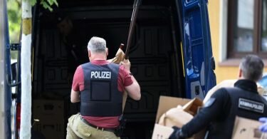 Polizisten tragen in Essen Gegenstände, darunter mehrere Stichwaffen und Speere, aus dem Wohnhaus des Verdächtigen. Foto: David Young/dpa
