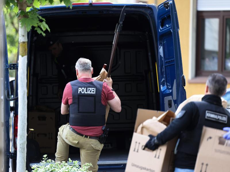 Polizisten tragen in Essen Gegenstände, darunter mehrere Stichwaffen und Speere, aus dem Wohnhaus des Verdächtigen. Foto: David Young/dpa