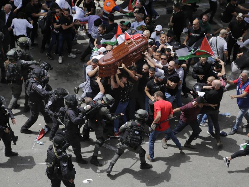 Israelische Polizisten stoßen mit palästinensischen Trauernden, die den Sarg der getöteten Al-Dschasira-Reporterin Abu Akle tragen, zusammen. Während der Prozession ihrer Beerdigung ist es zu Konfrontationen gekommen. Foto: Maya Levin/AP/dpa
