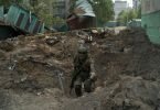 Ein Uniformierter inspiziert einen Krater nach einem Luftangriff der russischen Streitkräfte in der Region Luhansk. Foto: Leo Correa/AP/dpa