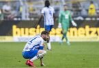 Der Berliner Marvin Plattenhardt hockt nach dem Schlusspfiff enttäuscht auf dem Dortmunder Rasen. Foto: David Inderlied/dpa