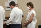 Der mutmaßliche Täter (r) steht in Handschellen neben seinem Anwalt, während die Anklage gegen ihn im Buffalo City Court verlesen wird. Foto: Mark Mulville/The Buffalo News via AP/dpa