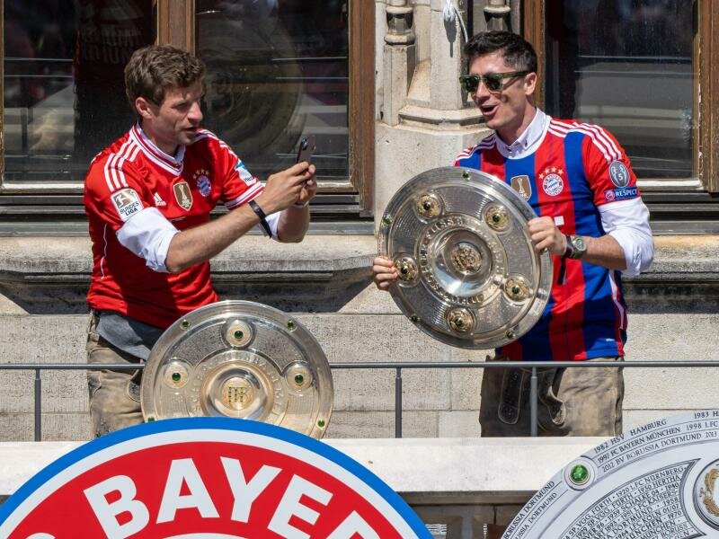 Thomas Müller (l) und Robert Lewandowski bei der Bayern-Meisterfeier auf dem Rathausbalkon. Foto: Peter Kneffel/dpa