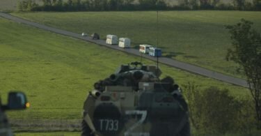 Busse mit ukrainischen Soldaten, die aus dem belagerten Stahlwerk Azovstal in Mariupol evakuiert wurden, fahren in Begleitung russischer Militärfahrzeuge zu einem Gefängnis in der «Volksrepublik» Donezk. Foto: Alexei Alexandrov/AP/dpa