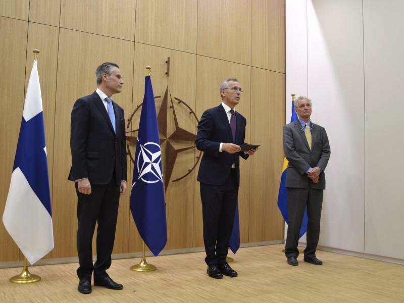 Der finnische Botschafter Klaus Korhonen (l) und der schwedische Botschafter Axel Wernhoff (r) überreichen dem Nato-Generalsekretär Jens Stoltenberg die Anträge ihrer Länder auf die Nato-Mitgliedschaft. Foto: Heta Hassinen/Lehtikuva/dpa