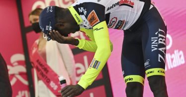 Biniam Girmay hatte sich nach seinem Etappensieg auf dem Podium den Korken des Siegersektes ins Auge geschossen. Foto: Massimo Paolone/LaPresse/AP/dpa