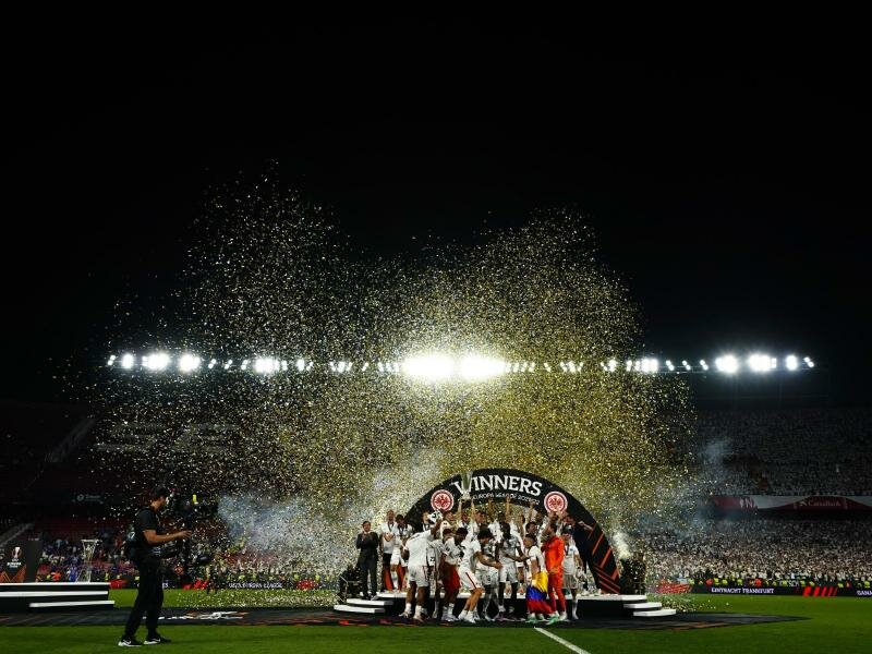 Nach dem Sieg feierten Frankfurts Spieler mit dem Pokal im Konfettiregen. Foto: Manu Fernandez/AP/dpa