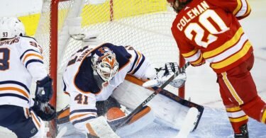 Mike Smith (l), Torwart der Edmonton Oilers, pariert gegen den Stürmer Blake Coleman von den Calgary Flames. Foto: Jeff Mcintosh/The Canadian Press via AP/dpa