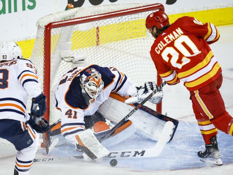 Mike Smith (l), Torwart der Edmonton Oilers, pariert gegen den Stürmer Blake Coleman von den Calgary Flames. Foto: Jeff Mcintosh/The Canadian Press via AP/dpa