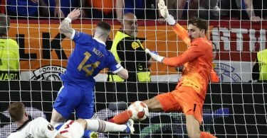 Frankfurts Torhüter Kevin Trapp (r) rettet gegen Ryan Kent (M) von den Rangers. Foto: Pablo Garcia/AP/dpa