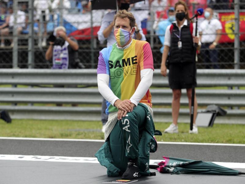 Aston-Martin-Pilot Sebastian Vettel kniet vor einem Rennen zur Unterstützung der Black-Lives-Matter-Bewegung nieder und trägt ein T-Shirt in Regenbogenfarben. Foto: Florion Goga/Pool Reuters/AP/dpa