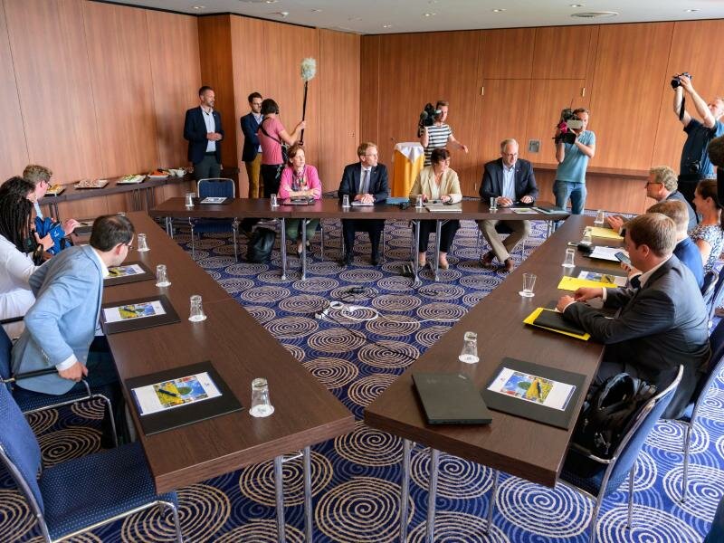 Die Verhandlungsteams von CDU (M), FDP (r) und Grünen in einem Kieler Hotel. Foto: Jonas Walzberg/dpa