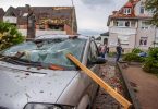 Eine Dachlatte steckt in der Windschutzscheibe eines parkenden Autos. Ein Unwetter hat auch in Paderborn große Schäden angerichtet. Foto: Lino Mirgeler/dpa