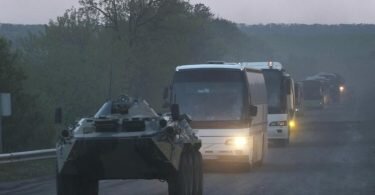 Ein APC der Miliz der sogenannten Volksrepublik Donezk begleitet Busse mit ukrainischen Soldaten zur Strafkolonie in Oljoniwka, nachdem sie das belagerte Stahlwerk Azovstal in Mariupol verlassen haben. Foto: Uncredited/AP/dpa