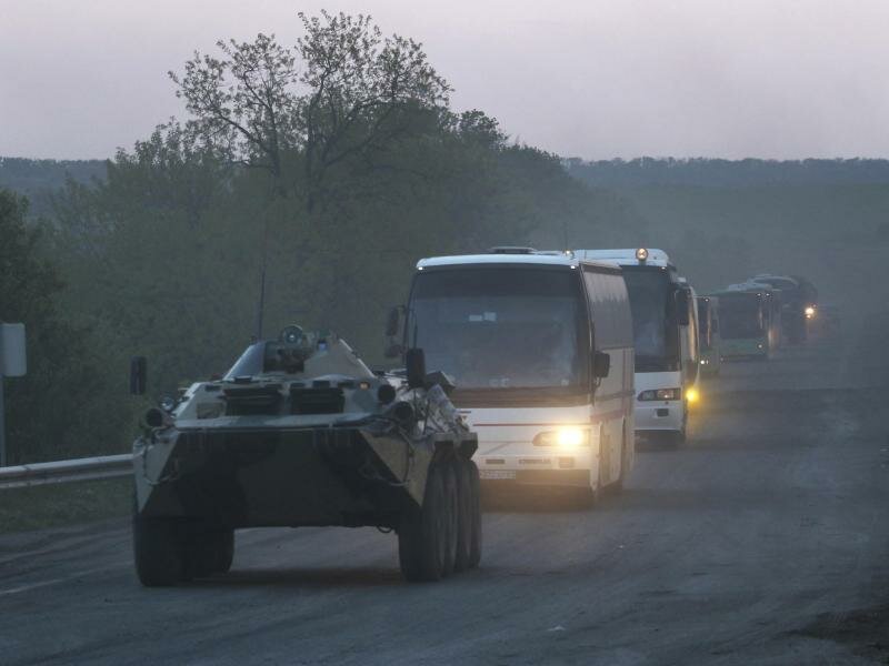 Ein APC der Miliz der sogenannten Volksrepublik Donezk begleitet Busse mit ukrainischen Soldaten zur Strafkolonie in Oljoniwka, nachdem sie das belagerte Stahlwerk Azovstal in Mariupol verlassen haben. Foto: Uncredited/AP/dpa