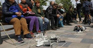 Menschen in Mariupol laden ihre Telefone auf - das Gebiet in der&nbsp;Ostukraine steht unter der Regierung der sogenannten Donezker Volksrepublik. Foto: Alexei Alexandrov/AP/dpa