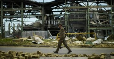 Ein ukrainischer Soldat geht an einer durch Beschuss zerstörten Fabrik vorbei. Foto: Francisco Seco/AP/dpa