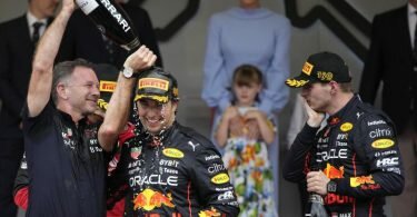 Sergio Perez aus Mexiko (M) feiert seinen Sieg in Monaco mit Red-Bull-Teamchef Christian Horner Teamkollege Max Verstappen. Foto: Daniel Cole/AP/dpa