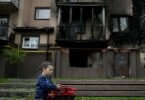 Vor einem zerstörten Gebäude in Irpin am&nbsp;Stadtrand von Kiew spielt der kleine Yarik mit seinem Spielzeug-Lastwagen. Foto: Natacha Pisarenko/AP/dpa