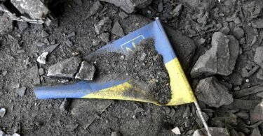 Eine ukrainische Fahne liegt nach einem Raketeneinschlag in den Trümmern einer Schule in Charkiw. Foto: Carol Guzy/ZUMA Press Wire/dpa