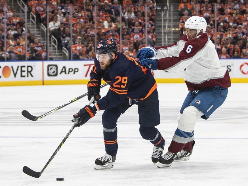 Erik Johnson (r) von Colorado Avalanche und Leon Draisaitl (l/29) von den Edmonton Oilers kämpfen um den Puck. Foto: Jason Franson/The Canadian Press/dpa