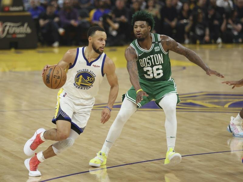 Stephen Curry (l), Guard der Golden State Warriors, zieht zum Korb gegen Marcus Smart, Guard der Boston Celtics. Foto: Jed Jacobsohn/AP/dpa