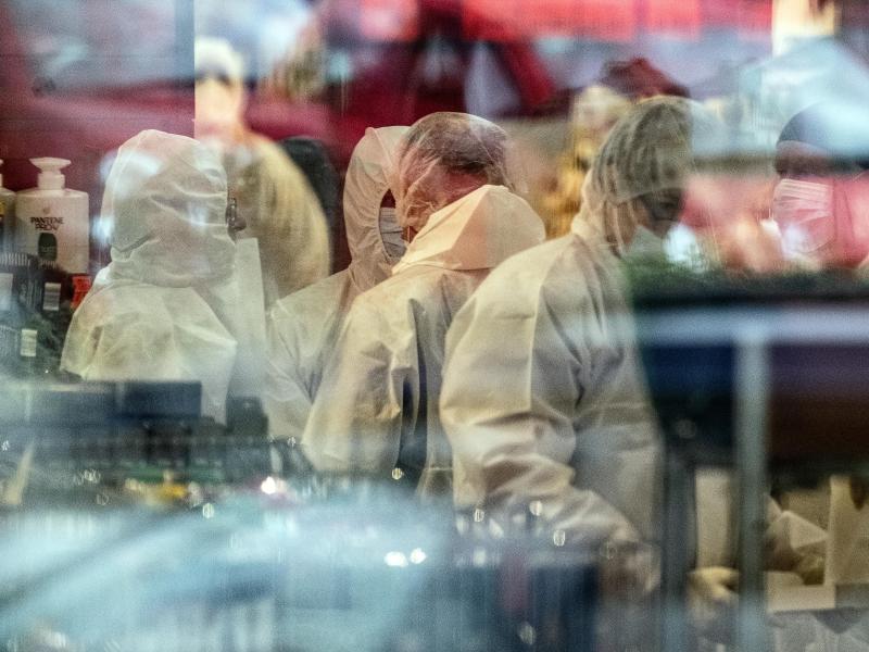 Kriminaltechniker stehen in dem Einkaufsmarkt, wo ein Mann nach Polizeiangaben vermutlich zuerst eine Frau und dann sich selbst erschossen hat. Foto: Swen Pförtner/dpa