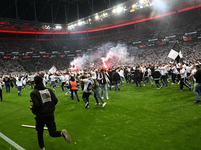 Der Platzsturm der eigenen Fans nach dem Sieg gegen West Ham United kommt Eintracht Frankfurt teuer zu stehen. Foto: Arne Dedert/dpa
