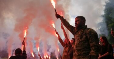 Soldaten halten Fackeln hoch, während sie an der Beerdigung des Aktivisten und Soldaten Roman Ratushny teilnehmen. Foto: Natacha Pisarenko/AP/dpa