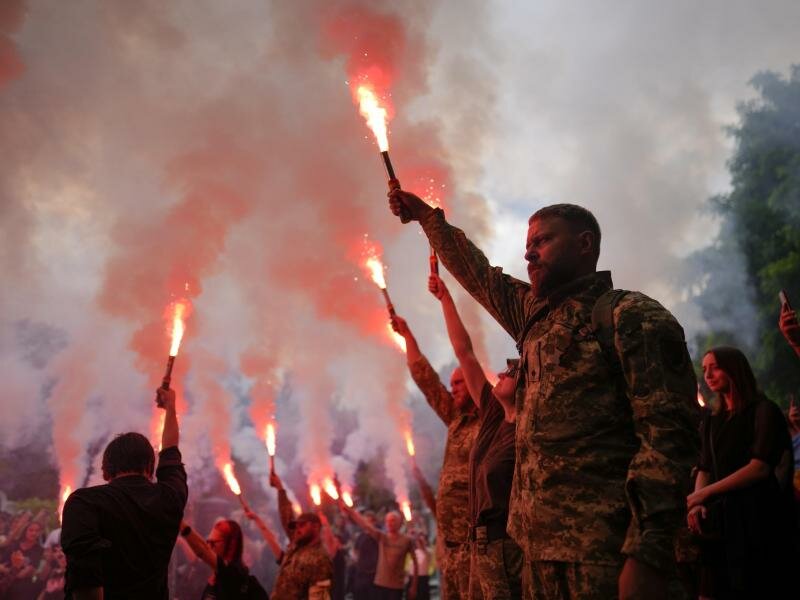 Soldaten halten Fackeln hoch, während sie an der Beerdigung des Aktivisten und Soldaten Roman Ratushny teilnehmen. Foto: Natacha Pisarenko/AP/dpa