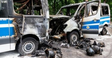 Zwei Mannschaftsbusse der Polizei stehen vor einem Hotel in MÜnchen. Foto: Matthias Balk/dpa