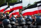 Anhänger der rechtsextremen Kleinstpartei «Die Rechte» lassen bei einer Demonstration in Kassel ihre Fahnen wehen. Foto: Swen Pförtner/dpa