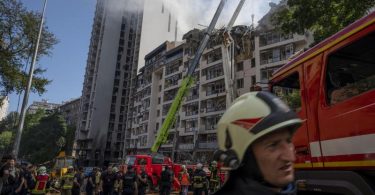 Feuerwehrleute nach schweren Explosionen an einem beschädigten Wohnhaus in Kiew. Foto: Nariman El-Mofty/AP/dpa