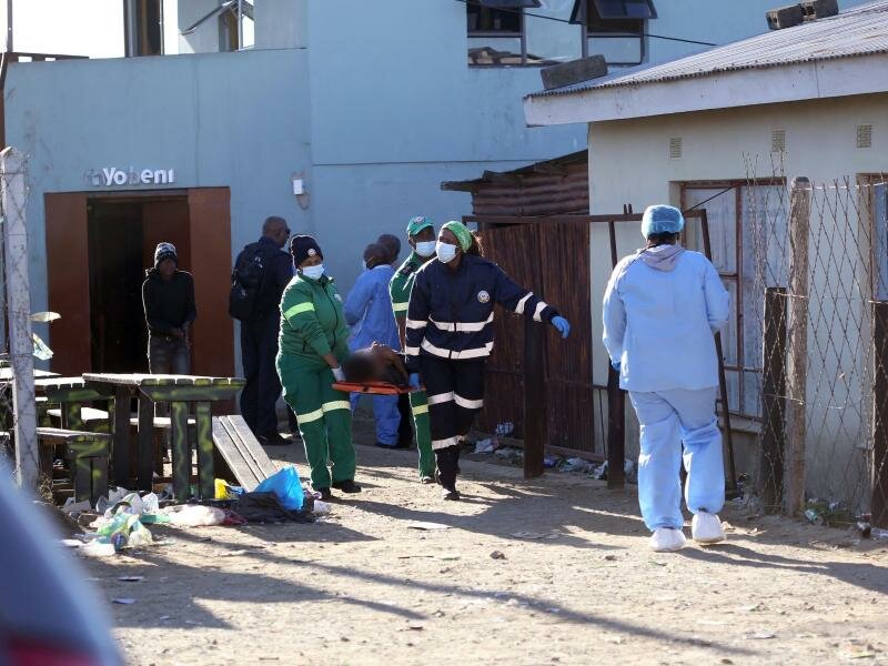 Einsatzkräfte tragen eine Leiche aus dem Nachtclub in der südafrikanischen Stadt East London. Foto: Uncredited/AP/dpa