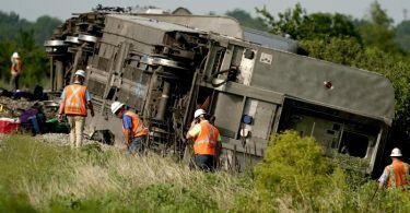 Arbeiter inspizieren die Stelle, an der der Zug entgleiste. Foto: Charlie Riedel/AP/dpa