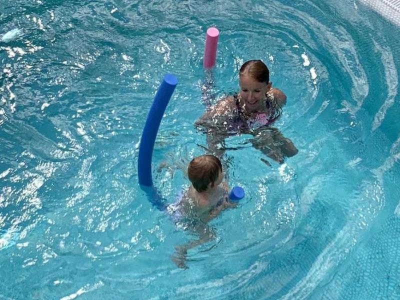 Eine Trainerin übt mit einem Keinkind in einem Becken Schwimmen. Foto: Bösel-Weßler/Aqua Marys Swimacademy/dpa