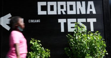 «Corona Test» und ein Richtungspfeil steht auf einer Garage während eine Person vorüber geht. Corona-Bürgertests für alle sollen künftig drei Euro kosten. Foto: Annette Riedl/dpa