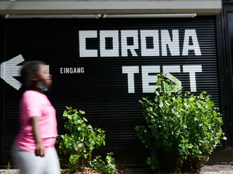 «Corona Test» und ein Richtungspfeil steht auf einer Garage während eine Person vorüber geht. Corona-Bürgertests für alle sollen künftig drei Euro kosten. Foto: Annette Riedl/dpa