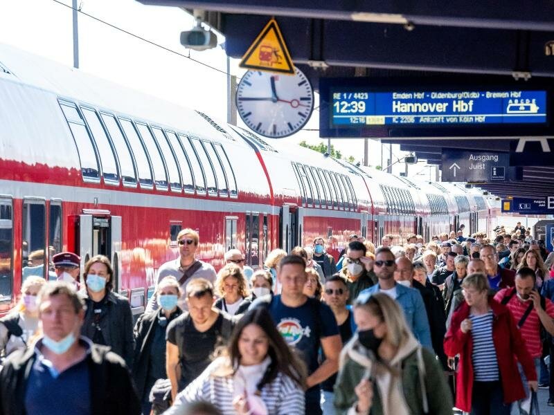 Reisende am Bahnhof Norddeich Mole in Niedersachsen. Foto: Sina Schuldt/dpa