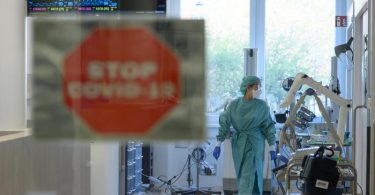 Eine Intensivpflegerin läuft in der Corona-Intensivstation des Universitätsklinikums Dresden über den Gang. Foto: Robert Michael/dpa-Zentralbild/dpa