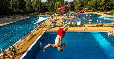 Es ist heiß. Ein junger Mann in Brandenburg springt ins Wasserbecken. Foto: Frank Hammerschmidt/dpa