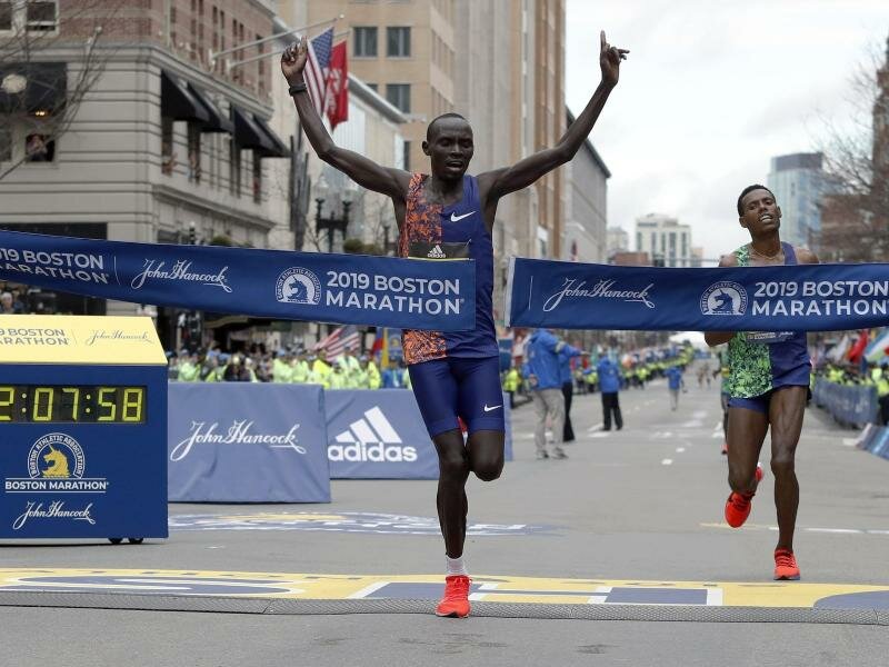 Für die WM gesperrt: Boston-Sieger Lawrence Cherono (M) aus Kenia zerreißt das Band auf der Ziellinie. Foto: Winslow Townson/FR170221 AP/dpa