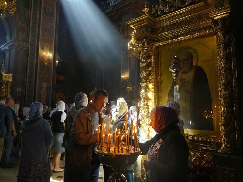 Menschen zünden in der orthodoxen Kirche von Winnyzja Kerzen zum Gedenken an die Menschen an, die durch russischen Beschuss getötet wurden. Bei dem Raketenangriff kamen jüngsten Informationen zufolge mindestens 24 Menschen ums Leben. Foto: Efrem Lukatsky/AP/dpa