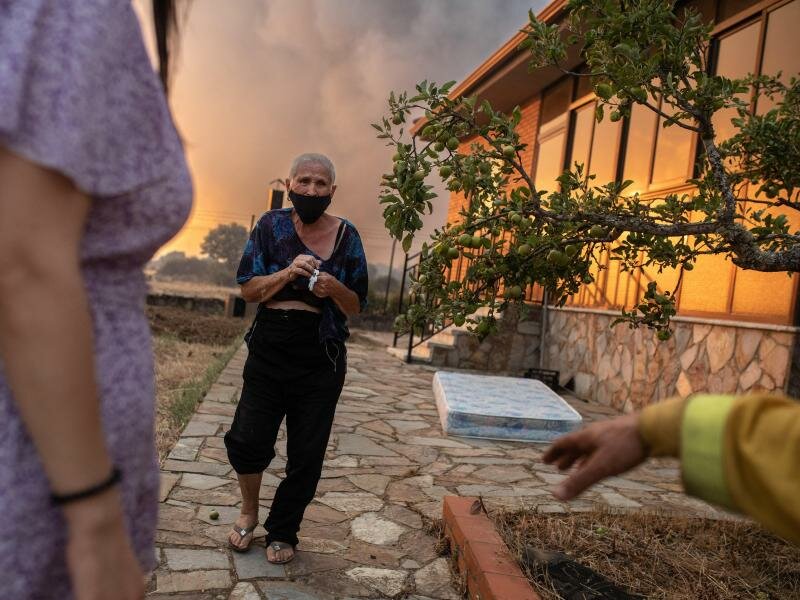 Eine Frau wird wegen der Nähe der Flammen eines Waldbrandes im spanischen Losacio evakuiert. Foto: Emilio Fraile/EUROPA PRESS/dpa