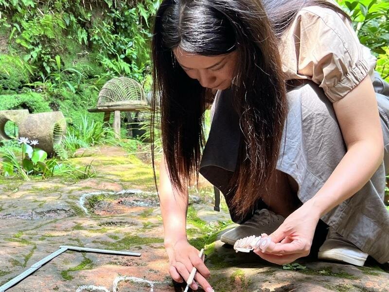 Eine Wissenschaftlerin im Forscherteam von Lida Xing untersucht die etwa 100 Millionen Jahre alte Dinosaurier-Fußabdrücke. Foto: ---/Lida Xing Team/dpa