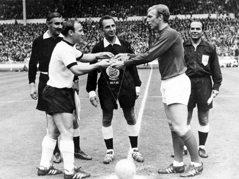 Uwe Seeler (l) und Englands Kapitän Bobby Moore vor dem WM-Finale 1966 in Wembley. Foto: Uncredited/BIPPA/dpa