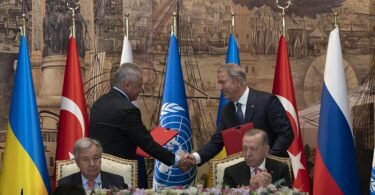 Antonio Guterres (vorne l.) und Recep Tayyip Erdogan (r.) - zwei Vertreter der Delegationen der Ukraine und Russlands reichen sich die Hände. Foto: Khalil Hamra/AP/dpa